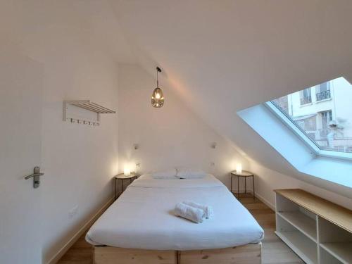 Cette chambre blanche dispose d'un lit et d'une fenêtre. dans l'établissement Mascate - Appartement Climatisé en Hypercentre, à Reims