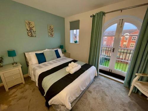 a bedroom with a bed with a teddy bear on it at Modern 2-Bed Home Free Parking Perfect for Families in Loughborough