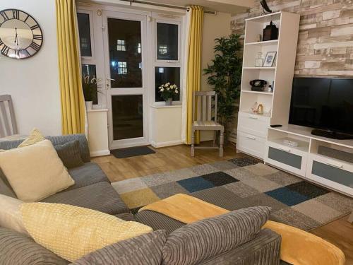 a living room with a couch and a tv at Modern 2-Bed Home Free Parking Perfect for Families in Loughborough