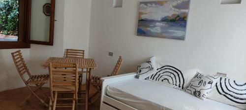 ポルト・チェルボにあるAppartamenti con piscina - Appartamentiflarida Porto Cervoのベッド、テーブル、椅子が備わる客室です。