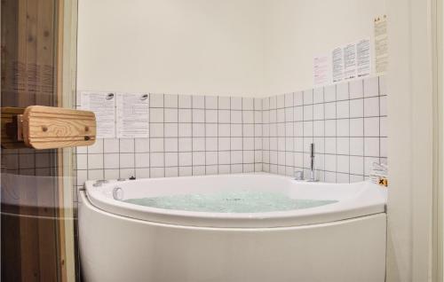 ThorsmindeにあるBeautiful Home In Ulfborg With 2 Bedrooms, Sauna And Wifiのバスルーム(青い水のバスタブ付)