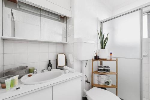 uma casa de banho branca com um lavatório e um espelho em Fitzroy North Boutique Bliss by Merri Creek Trail em Melbourne