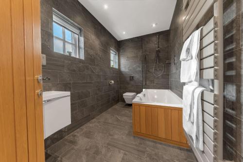 a bathroom with a tub and a toilet and a sink at Springbank Cottage, luxury Lake District cottage in Coniston in Coniston
