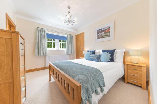a bedroom with a large bed and a window at Springbank Cottage, luxury Lake District cottage in Coniston in Coniston