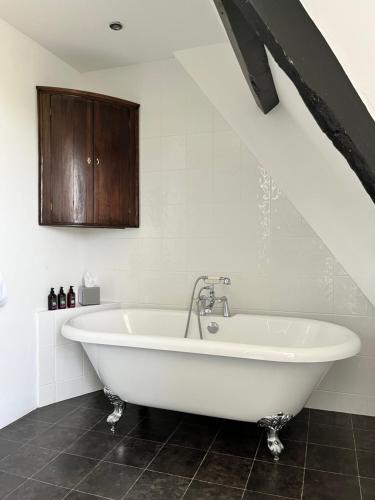 a white bath tub in a bathroom under an attic at Coed Mawr Hall Bed & Breakfast in Conwy