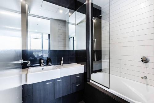 a bathroom with a sink and a shower and a tub at City View Chic in South Yarra with Parking in Melbourne