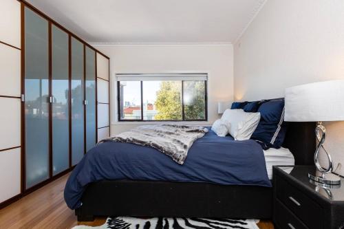 a bedroom with a large bed and a window at 'The Lighthouse' Character-filled Abode near Beach in Melbourne