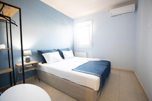 - une chambre dotée d'un grand lit blanc avec des draps bleus dans l'établissement PTapartment4, à Peraia