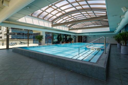 a large swimming pool in a building with a glass ceiling at Spacious Inner-city Stay with King Bed and Balcony in Melbourne