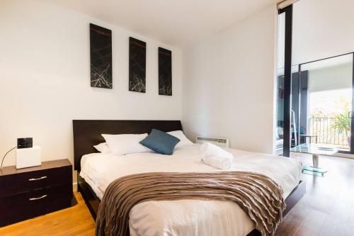 a bedroom with a large bed and a large window at Southside St Kilda Seclusion with Balcony and Parking in Melbourne