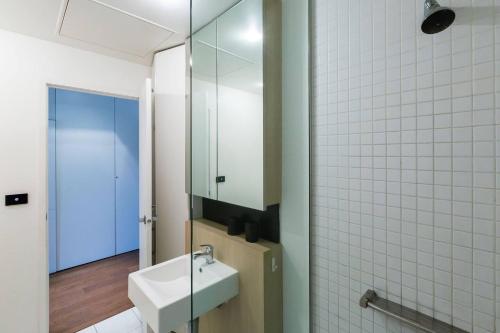un baño con lavabo y espejo en Southside St Kilda Seclusion with Balcony and Parking, en Melbourne