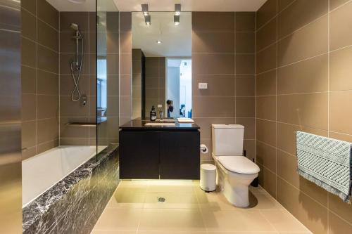 ein Bad mit einem WC, einem Waschbecken und einer Dusche in der Unterkunft Richmond Chic off Bridge Rd with Patio Parking in Melbourne
