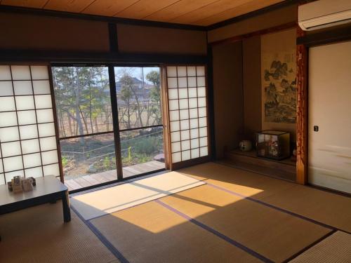 Habitación con ventanas y alfombras en フクロウの御宿 en Isawa