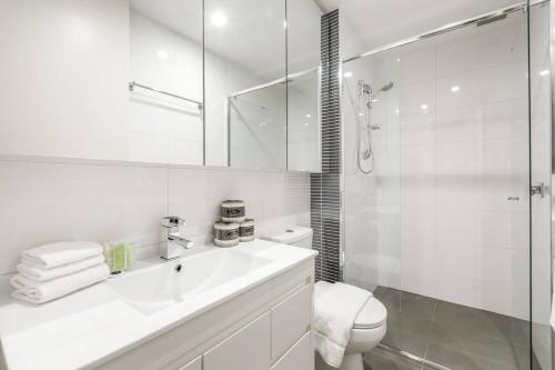 bagno bianco con lavandino e doccia di Nicholson's Nest - A Balcony Studio in Funky Fitzroy a Melbourne