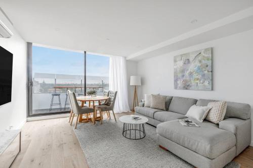 a living room with a couch and a table at The Nest on Nott - Pure Port Melbourne Bliss in Melbourne