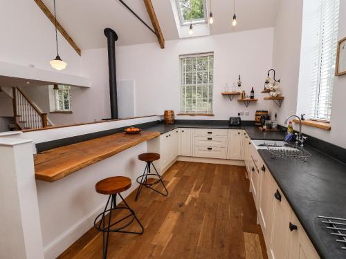 a kitchen with white cabinets and a wooden counter top at The Chapel in Alfreton