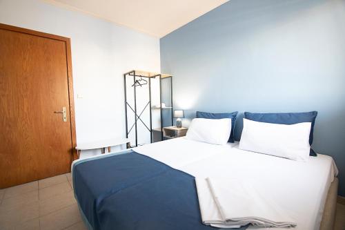 - une chambre dotée d'un grand lit avec des draps blancs et bleus dans l'établissement PTapartment4, à Peraia