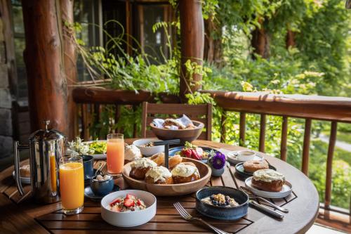 a wooden table with food and drinks on a porch at The Chatwal Lodge (All-Inclusive) - in The Unbound Collection by Hyatt in White Lake