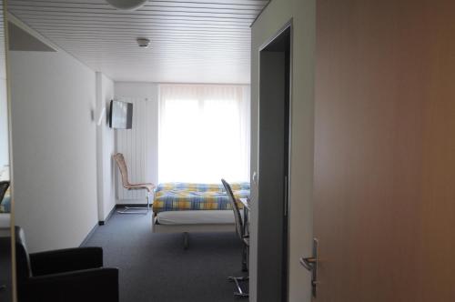 a hallway with a room with a window and a chair at Ferien- und Familienhotel Alpina Adelboden in Adelboden