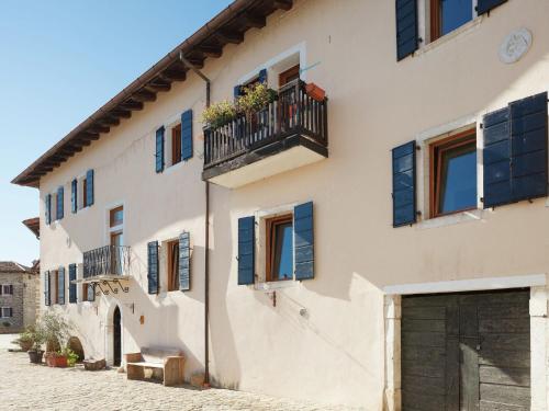 a building with blue shutters and a balcony at Traditional Apartment in Poffabro with Fireplace in Frisanco
