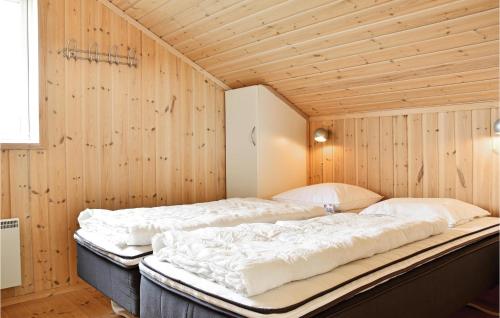 NørbyにあるSndervig Feriebyのベッド2台 木製の壁の部屋