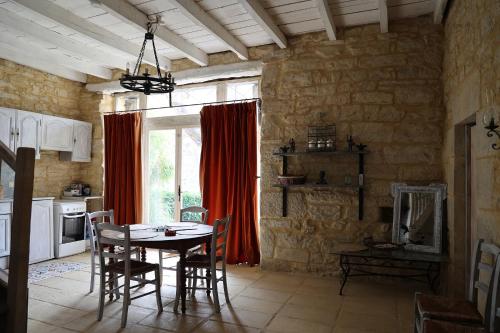 une cuisine avec une table et des chaises dans une pièce dans l'établissement Château de St Chamarand - Grand & Petit Gîtes, à Saint-Chamarand