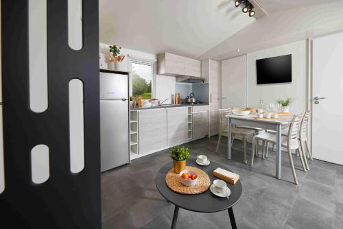 une cuisine et un salon avec une table et une salle à manger dans l'établissement LE MONDOU, à Saint-Julien-de-Lampon