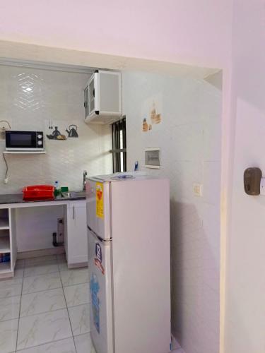 eine Küche mit einem weißen Kühlschrank und einer Theke in der Unterkunft Reserva africa 3D in Lomé