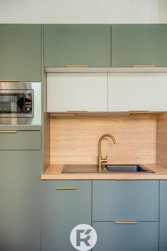 une cuisine avec des armoires blanches et un évier dans l'établissement R'Apparts T2 Simply Beautiful, à Grenoble