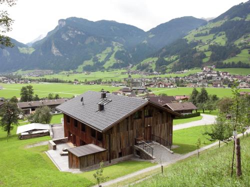 a barn in a field with mountains in the background at Grand Apartment in Mayrhofen with Infrared Sauna Artistic Interiors in Ramsau im Zillertal