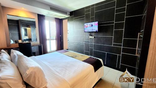 a bedroom with a bed and a tv on a wall at Sky dome resotel - โรงแรมสกายโดม รีโซเทล in Bangkok