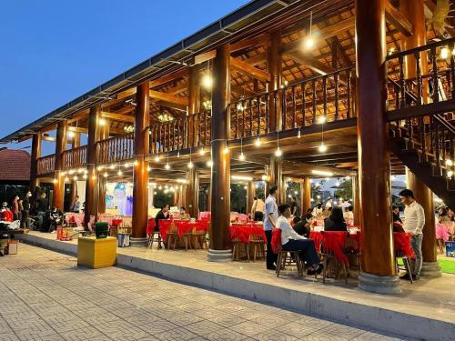 people sitting at tables outside of a restaurant at night at Dalis Waterfall Homestay in Lagi