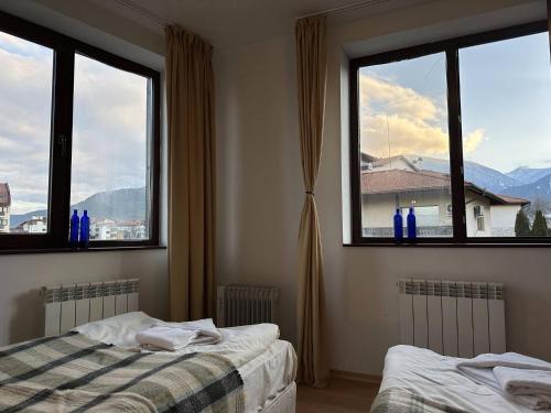 a bedroom with two beds and two windows at 2br Mountain View Apartment - 250mbps Wifi in Bansko