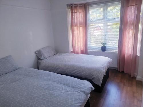 two beds in a small room with a window at double room in Thornton Heath