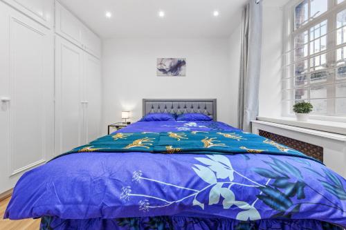 倫敦的住宿－Modern Flat in London，一间卧室配有一张带蓝色棉被的床
