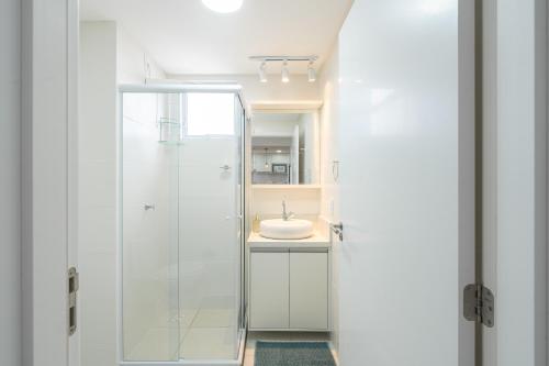 a bathroom with a glass shower and a sink at Apartamento com VISTA MAR, Ar-condicionado, Wi-Fi Condomínio com PISCINA, quadra de esportes Playground infantil a 15 minutos do Beto Carreiro in Piçarras
