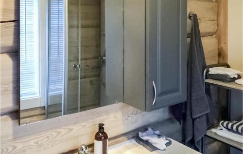 uma casa de banho com um lavatório e um chuveiro com um espelho. em 2 Bedroom Awesome Apartment In Edland em Vågsli