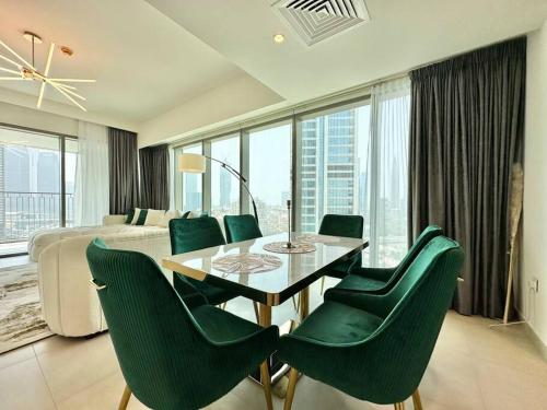 ein Esszimmer mit einem Tisch und grünen Stühlen in der Unterkunft Burj Khalifa View! Downtown Dubai in Dubai