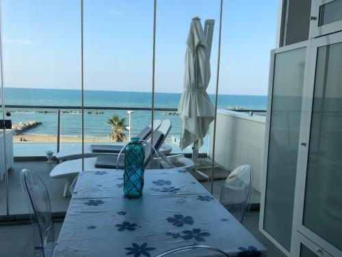 - une salle à manger avec une table et une vue sur la plage dans l'établissement Acqua di mare tra alba e tramonto, à Termoli