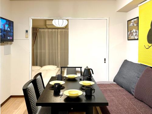 a living room with a table and a couch at 山手線池袋駅 徒歩6分 東池袋駅徒歩3分 2~5人 エレベーター WIFI 新宿/渋谷/銀座/築地/浅草/原宿近い！ in Tokyo