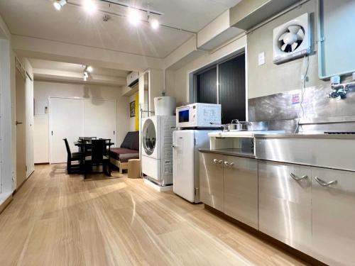 a large kitchen with a table in a room at 山手線池袋駅 徒歩6分 東池袋駅徒歩3分 2~5人 エレベーター WIFI 新宿/渋谷/銀座/築地/浅草/原宿近い！ in Tokyo