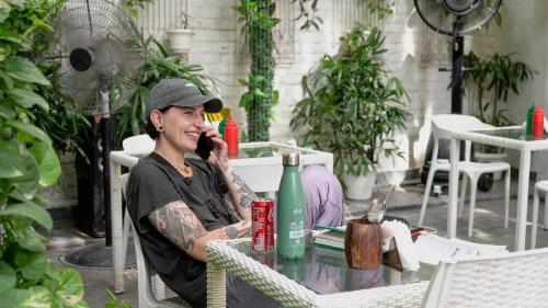 a woman sitting at a table talking on a cell phone at Stay Banaras - A Boutique Hotel in Varanasi
