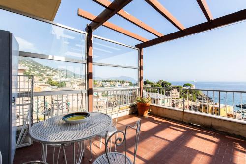 balkon ze stołem i krzesłami oraz oceanem w obiekcie Panoramic sea view w Genui