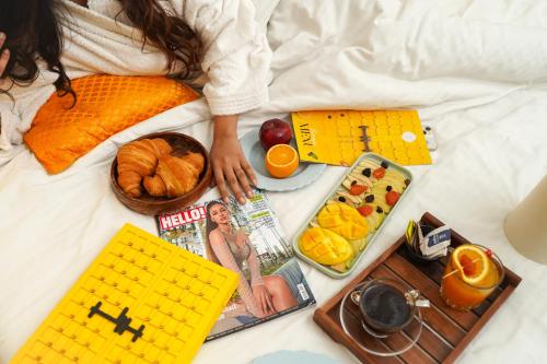 a person laying on a bed with food and toys at Stay Banaras - A Boutique Hotel in Varanasi