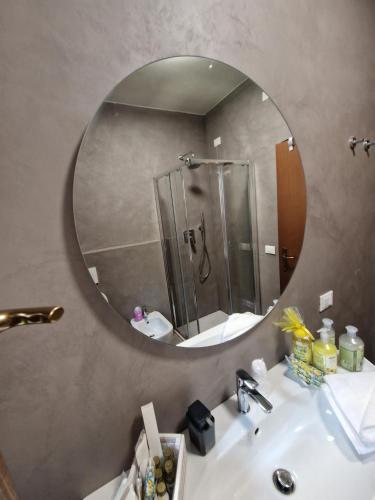 a bathroom with a mirror and a sink with a shower at Appartamento Vista Forra in Tremosine Sul Garda