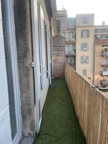 - un balcon avec de l'herbe verte sur le côté du bâtiment dans l'établissement Appartement Marseille 13008 - 5min à pied Stade Vélodrome, à Marseille
