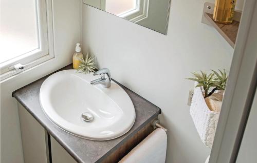 uma casa de banho com um lavatório branco e um espelho. em Beautiful Home In Hvide Sande With Wifi em Hvide Sande