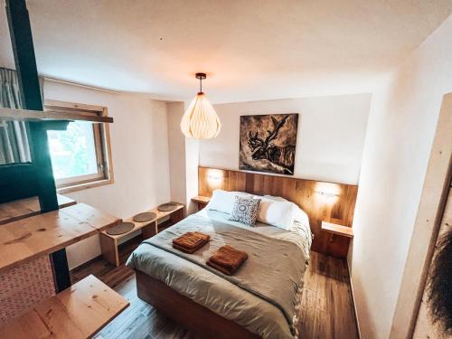 een kleine slaapkamer met een bed en een bureau bij Le Peyra, Apt 4 personnes avec terrasse et jardin in Le Monêtier-les-Bains