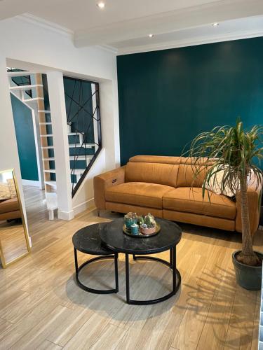 a living room with a couch and a table at Maison 6 personnes 3 chambres proche grand stade Pierre mauroy in Camphin-en-Pévèle