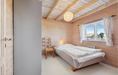 ein Schlafzimmer mit einem Bett in einer Holzwand in der Unterkunft Lovely Home In Ulfborg With House Sea View in Ulfborg